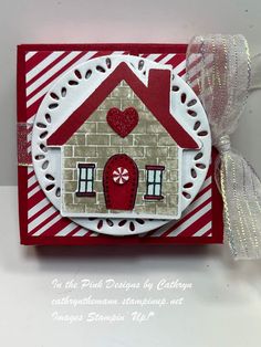 a red and white card with a house on it