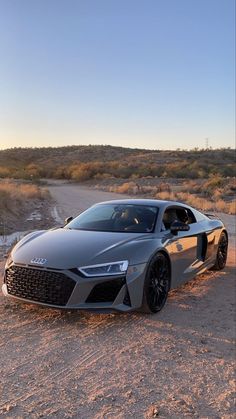 a grey sports car parked in the desert