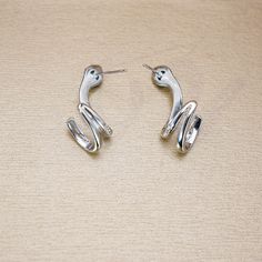 ✰ This delicate jewelry is perfect for people who want to achieve a brilliant and splendid look ✰ This Snake Shaped Earrings not only suitable for formal occasions such as banquets, weddings, theme parties, but also for everyday wear ✰ This delicate jewelry is a very special gift for birthday, Mother's Day, Valentine's Day,Christmas, Winter Clothing and more ✰ Comes with an exquisite gift box Materials: Environmentally-friendly Copper Quantity: 1 pair ----♛ PRODUCTION & SHIPPING ♛ --- ✰ Multiple items purchased in one payment can be combined for shipping ✰ Visit our store, browse other jewelry collections, and find the perfect piece you're looking for：https://www.etsy.com/shop/iCoolJewelry ----♛ Care Tips ♛ --- ✰ Scratches from daily wear are normal, and they can be more noticeable on a la Silver Plated Hoop Earrings As Gift, Silver Dangle Hoop Earrings With Plating, Elegant Snake Shape Earrings With Ear Wire, Minimalist Silver Snake-shaped Jewelry, Adjustable Snake-shaped Metal Jewelry, Silver Snake Shape Earrings, Snake-shaped Pierced Earrings For Gift, Snake-shaped Earrings For Gifts, Silver Snake-shaped Party Earrings