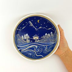 a hand is holding a blue and white plate