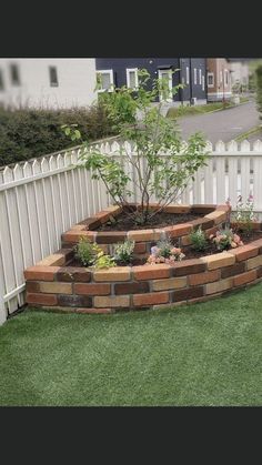 a white picket fence surrounding a garden area