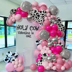 the balloon arch is decorated with pink, silver and black balloons