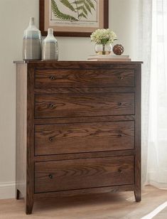 a wooden dresser with vases on top of it