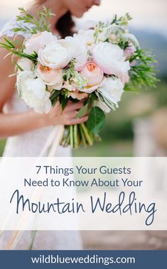 a bride holding a bouquet of white flowers and greenery