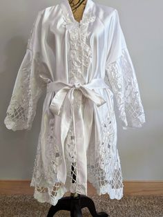 a white robe on a mannequin with laces and ribbon around the waist