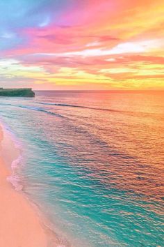 the beach is lined with white sand and blue water as the sun sets over the ocean