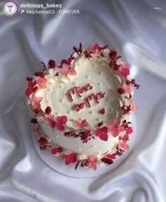 a white cake with red and pink flowers on it that says happy mother's day