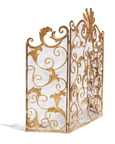 an ornate gold and white fireplace screen with scroll work on the sides, set against a white background