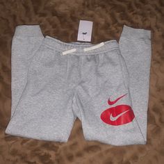 Heather Grey Boys Size M Red Nike Logo Standard Fit Taper Leg Regular Length New With Tags Winter Sportswear Red Bottoms, Nike Casual Bottoms With Letter Print, Nike Cotton Winter Joggers, Nike Cotton Winter Bottoms, Casual Nike Bottoms With Letter Print, Nike Winter Cotton Bottoms, Nike Red Sweatpants For Loungewear, Nike Red Pants For Streetwear, Casual Red Nike Sweatpants