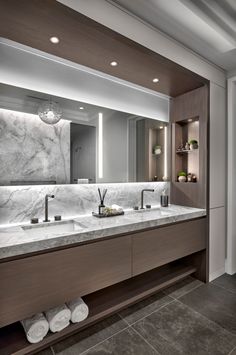 a large bathroom with two sinks and marble counter tops on both sides of the mirror