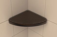 the corner of a shower stall with a brown floor drainer on it's side