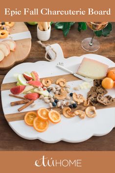 a white plate topped with lots of food on top of a wooden table next to a glass of wine