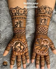 two hands with henna designs on them, one is showing the letter j and the other