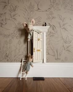 two stuffed animals sitting on top of a stepladder in front of a door