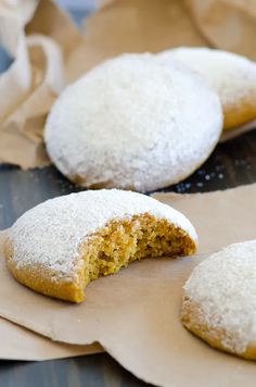 some sugar covered cookies are on top of brown parchment paper and have been cut in half