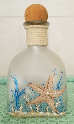 a glass bottle with a starfish painted on it