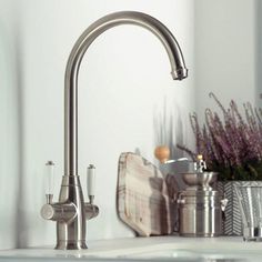 a faucet that is on the side of a sink in a room with white walls