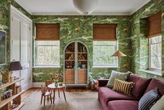 a living room filled with furniture and green wallpaper