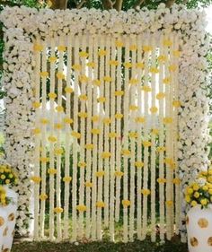 a white and yellow wedding backdrop with flowers