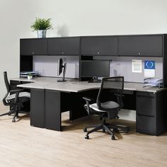 an office cubicle with two desks and chairs