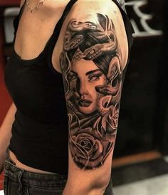 a woman's arm with tattoos on it and roses in her hair is shown