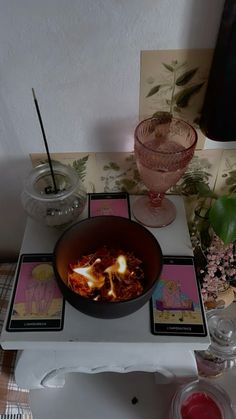 a bowl of food sitting on top of a table next to two cards and a candle