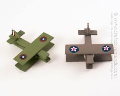 two toy airplanes sitting next to each other on a white surface