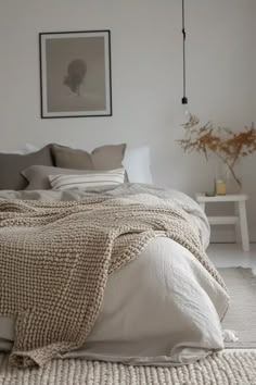 a bed with white sheets and pillows in a room