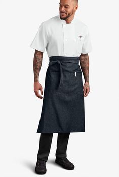 a man wearing an apron and black shoes standing in front of a white background with his hands on his hips