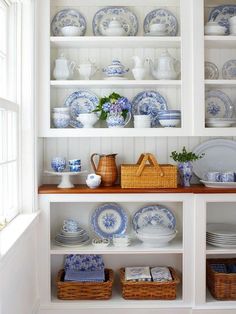 a white china cabinet filled with blue and white dishes