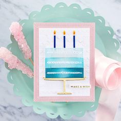 a card with a cake on it and some pink flowers