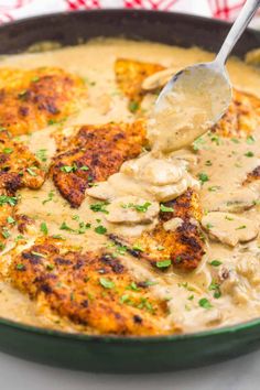 a skillet filled with chicken and gravy on top of a white table