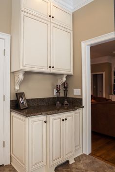 a kitchen with white cupboards and granite counter tops in the center of the room