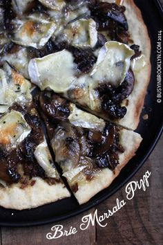 a close up of a pizza on a plate with toppings cut into slices and sitting on a wooden table