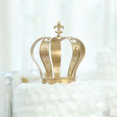 a gold crown sitting on top of a white cake