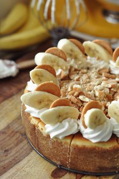 there is a cake with bananas and whipped cream on the top, sitting on a table