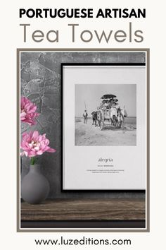 a vase with pink flowers sitting on top of a table next to a black and white photo