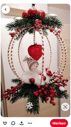 a christmas ornament with a snowman and heart hanging from it's center