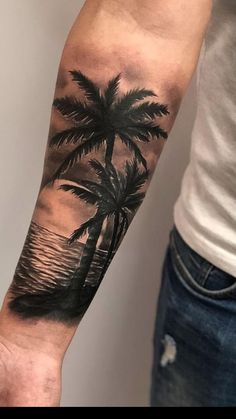 a man's arm with a palm tree and ocean scene tattoo on the left forearm