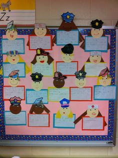 a bulletin board with paper cut out of people's faces and hats on it