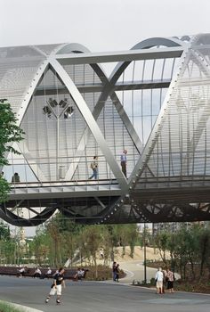 people are walking across a bridge that has been designed to look like an upside down building