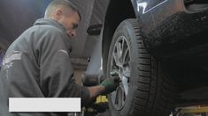 a man working on a tire in a garage