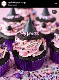 some cupcakes with pink frosting and black hats on top are sitting next to confetti sprinkles