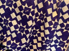 a large purple and white quilt on display