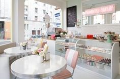 the inside of a bakery with tables and chairs