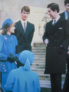 two men and one woman are talking to each other in front of some stairs with steps behind them