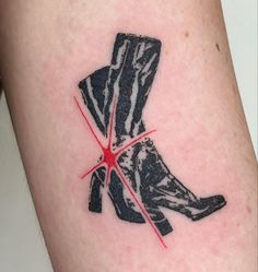 a tattoo on the leg of a person with a pair of boots