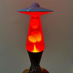 a lamp that is sitting on top of a wooden stand with balls in the shape of an alien