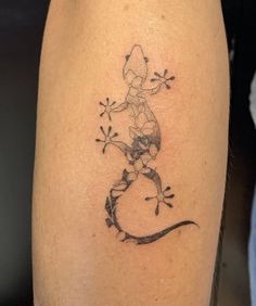 a tattoo on the leg of a woman with a lizard and flowers in her hair