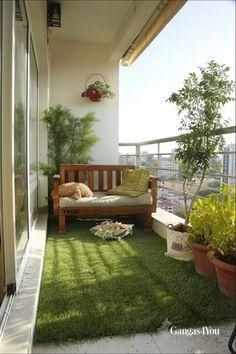 an apartment balcony with green grass and potted plants